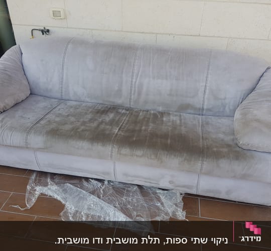 ספה אפורה עם כתמים על הרצפה